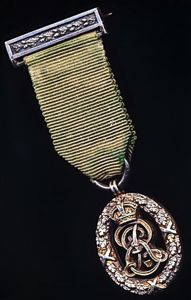 United Kingdom: Volunteer Decoration. With EDVII obverse cypher and the riband complete with the integral silver top brooch bar (with pin & clasp fittings)